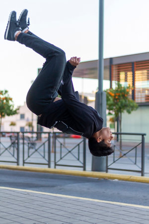 Active Latino young man jumping in action. Extreme sport activity, parkour outdoor free running or healthy lifestyle conceptの写真素材