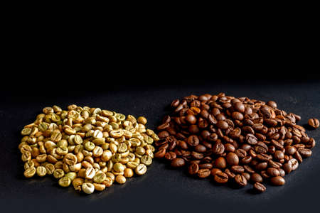 Unroasted and roasted coffee beans of the Robusta variety on a black background. Green unroasted coffee on the left and brown roast on the right on a black background.の写真素材
