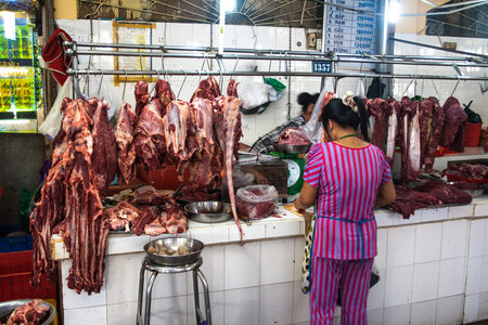 Young woman selling fresh meat at the weekly market in the center Saigon, Vietnam.