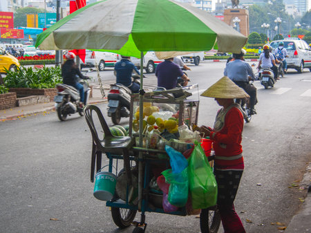 Young woman selling fresh fruits center in Saigon, Vietnamのeditorial素材