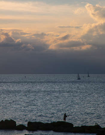 Fisherman on rocks in south Italyの写真素材