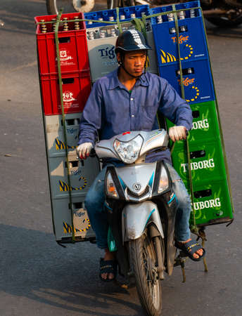 Vietnamese driving a motorbike and transporting a lot of packages. This is a typical Vietnam transport with motorcycle or scooterのeditorial素材