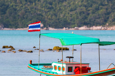 Thai flag and fishermen boat near Thong Nai Pan Yai Beach, Koh Panghan island, Thailandのeditorial素材