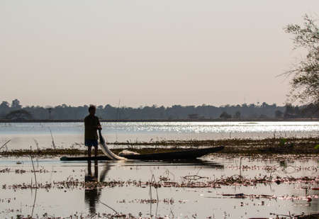 fisherman on canoe in tropical Bungva lake, Laoのeditorial素材