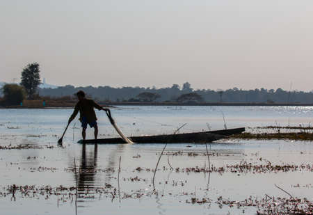 fisherman on canoe in tropical Bungva lake, Laoのeditorial素材
