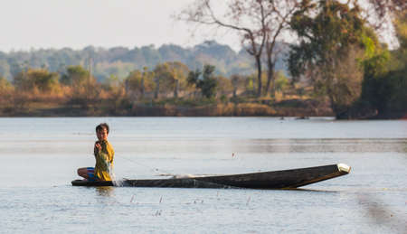 fisherman on canoe in tropical Bungva lake, Laoのeditorial素材