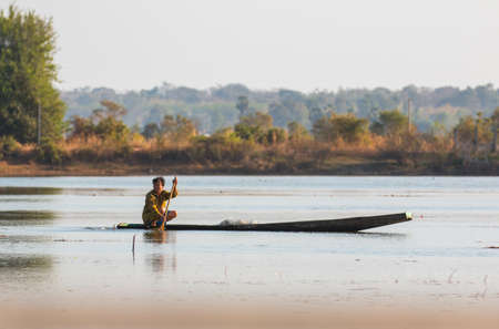 fisherman on canoe in tropical Bungva lake, Laoのeditorial素材