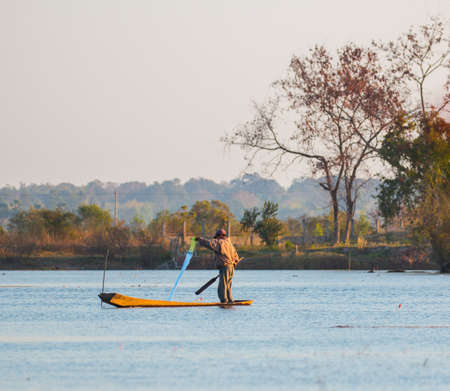 fisherman on canoe in tropical Bungva lake, Laoのeditorial素材