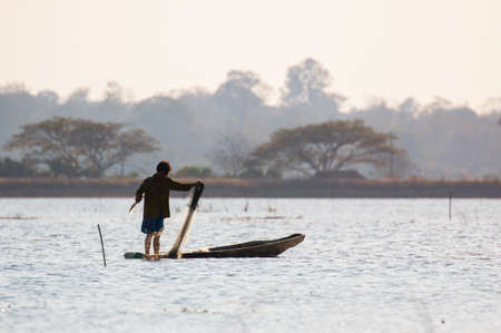 fisherman on canoe in tropical Bungva lake, Laoのeditorial素材