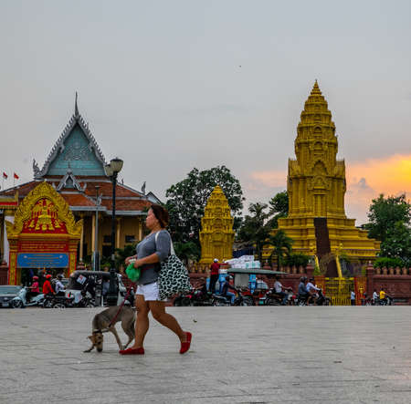 woman with dog at sunset near Wat Ounalom, a famous historical site in Phnom Penh, Cambodiaのeditorial素材