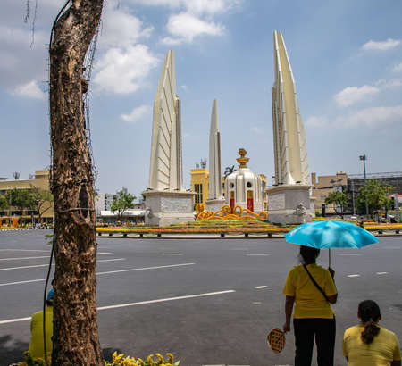 Thai people wear yellow shirts and with colored umbrellas and are waiting for His Majesty King Maha Vajiralongkorn Bodindradebayavarangkun or King Rama X, near Democracy Monument, Bangkok, Thailandのeditorial素材