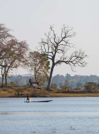 fisherman on canoe in tropical Bungva lake, Laosの写真素材