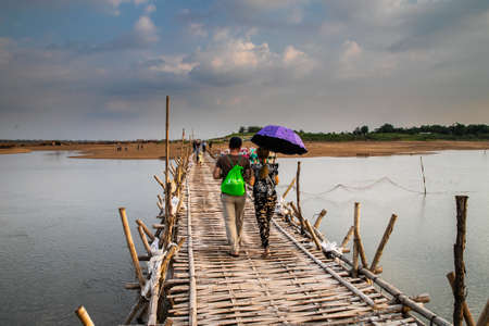 couple of lovers crossing old traditional bamboo wooden bridge across Mekong river (from Koh Paen island to Kampong Cham), Cambodiaのeditorial素材