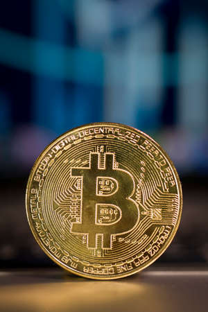 Close up on a bitcoin token on blurred financial infographicの写真素材