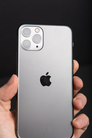 Milan, Italy - December 17, 2019: close up on a handheld brand new Apple iPhone 11 Pro on a black...