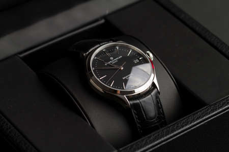 Milan, Italy - December 28, 2019: close up on a black Baume & Mercier man wristwatch, standing in its original package on black background.のeditorial素材