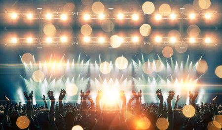 Colorful concert crowd in front of a lit stage inside a concert venue, during a music festival