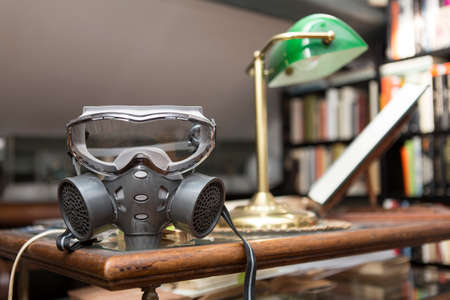 Coronavirus concept: close up on a gas mask placed inside a domestic interior.の写真素材