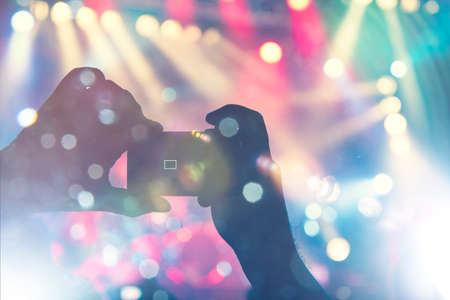 Shot taken during a music festival inside a concert hall. People are visible clapping the main stage.の写真素材