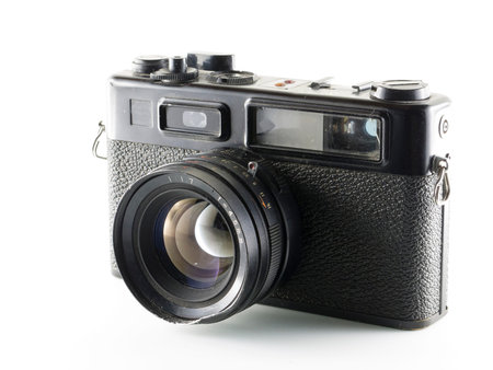 Close up on a vintage film camera, resting on white background.