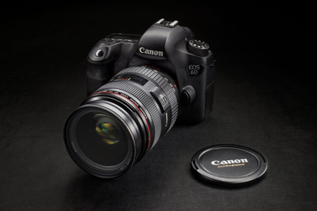 Milan, Italy - March 28, 2020: close-up on a Canon EOS 6D dslr camera resting on black background.