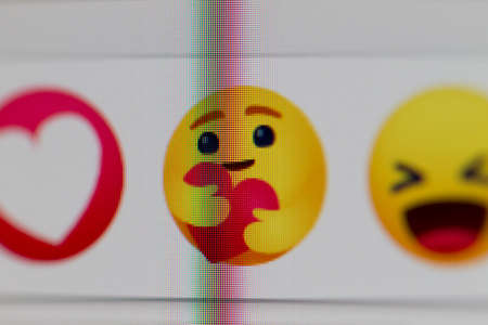 Milan, Italy - May 10, 2020: Facebook icon with new Care Empathetic Emoji Reaction, photographed on monitor. Facebook has added a hug reaction to show you care during the COVID-19 pandemic of 2020のeditorial素材