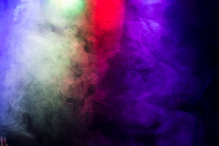 Abstract with coloured smoke on black background.の写真素材
