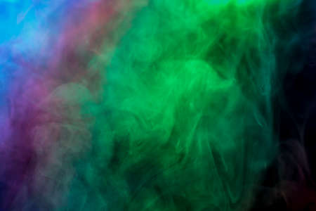 Abstract with coloured smoke on black background.の写真素材