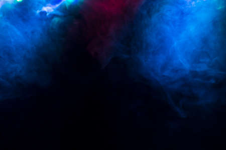 Abstract with coloured smoke on black background.の写真素材