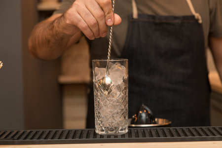 Detail of a cocktail preparation, background is a blurred pub interior.の写真素材