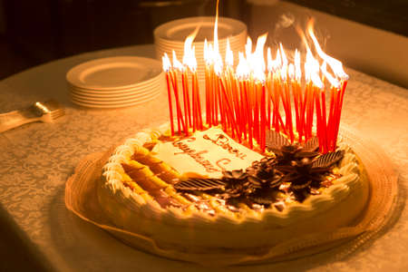 Detail of a birthday cake candles burning in a dark environmentの写真素材
