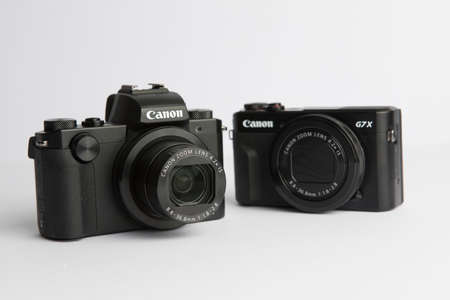 Milan, Italy - 17 June 2020: close up on Canon point and shoot cameras resting on white background.のeditorial素材