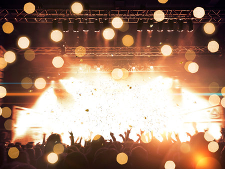 Concert spectators in front of a bright stage with live music