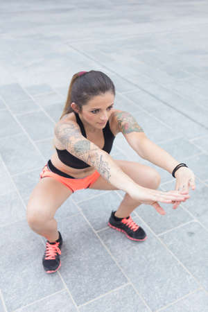 Urban style portrait of a strong young woman performing sport activities outdoorsの写真素材