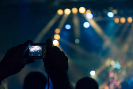 Concert photography during a gig, this is the point of view of the crowd in front of a stage during a music festivalの写真素材