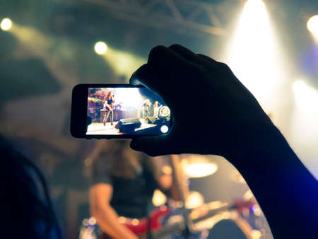 Concert photography with a smartphone during a music festivalの写真素材