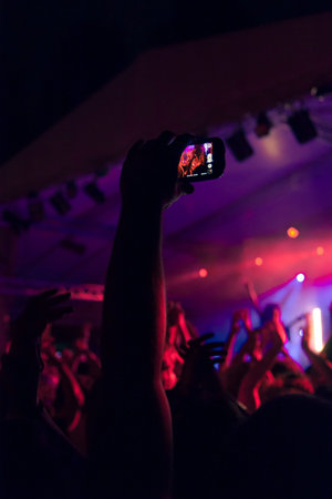Concert crowd point of view in front of a lit stage for a night festival