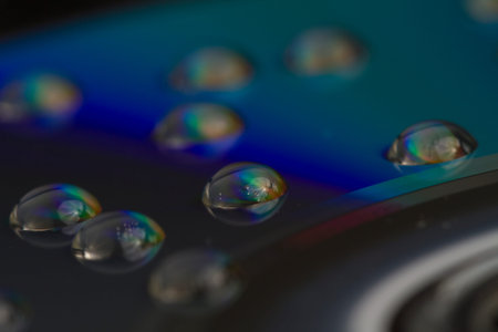 Macro shot of water drops on a CD surface for an abstract background.の写真素材