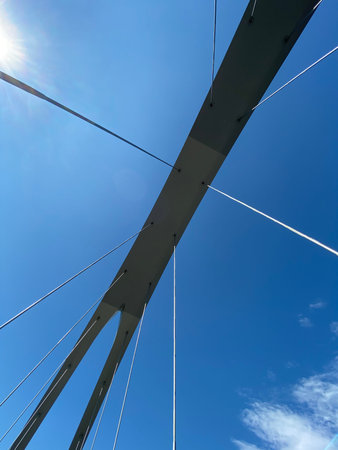 Looking op to a bridge structure against blue sky, no people are visible.の写真素材
