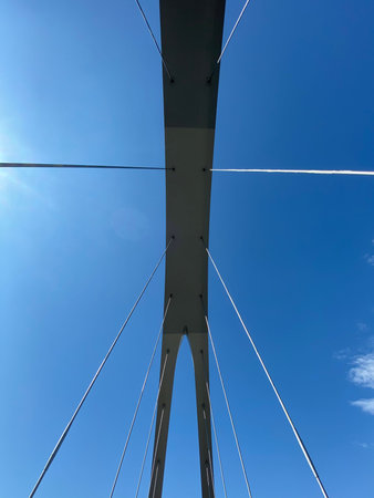 Looking op to a bridge structure against blue sky, no people are visible.