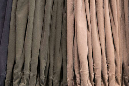 Close up detail of clothes hanging inside a closet, no people are visible.の写真素材
