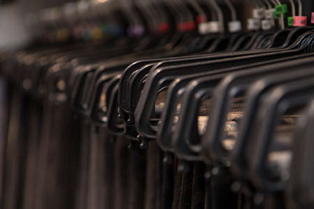 Close up detail of clothes hanging inside a closet, no people are visible.の写真素材