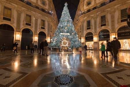 Milan, Italy - December 10, 2020: street view of the Christmas tree in Galleria Vittorio Emanuele at night, few people are barely visible in the distance.のeditorial素材