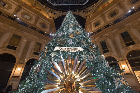 Milan, Italy - December 10, 2020: street view of the Christmas tree in Galleria Vittorio Emanuele at night, few people are barely visible in the distance.のeditorial素材