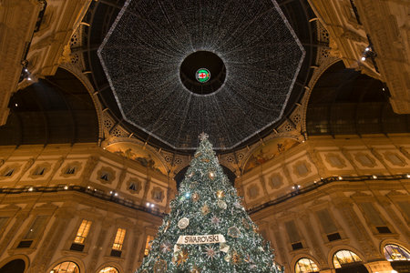 Milan, Italy - December 10, 2020: street view of the Christmas tree in Galleria Vittorio Emanuele at night, few people are barely visible in the distance.のeditorial素材