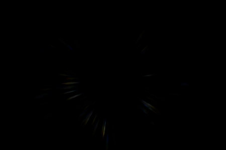 Coloured optical lens flare on black background.の写真素材