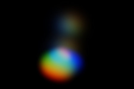 Coloured optical lens flare on black background.