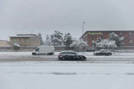 Milan, Italy - December 28, 2020: street view of Milan during the snow blizzard of late December, people are visible in the distance.のeditorial素材