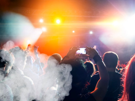 Many people together in front of harsh lights, lens flare is visible.の写真素材