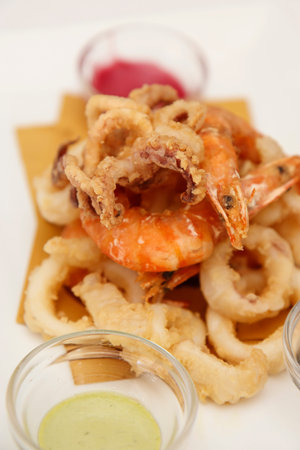 Fried squid rings with mayonnaise on plate, closeup